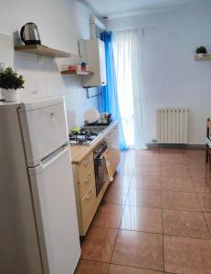 Il comprend une cuisine équipée d'un réfrigérateur blanc. dans l'établissement Bilocale3 a pochi passi da Milano, à Sesto San Giovanni
