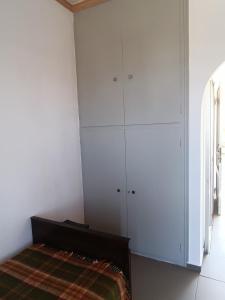 a bedroom with white cabinets and a bed with a blanket at GOLDEN BEACH in Souvala