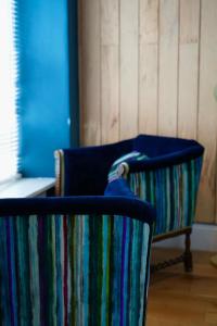 a blue chair sitting in a room at Arosfa Harbourside Guesthouse in Aberaeron