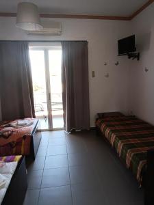 a hotel room with two beds and a sliding glass door at GOLDEN BEACH in Souvala