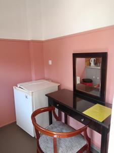 a room with a desk with a mirror and a refrigerator at GOLDEN BEACH in Souvala
