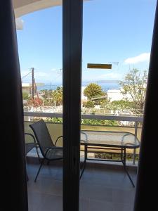 a balcony with a bench and a view of the ocean at GOLDEN BEACH in Souvala