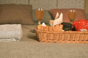 a basket of bread and two glasses of wine on a couch at B&B SEBA e PAOLA in Sonnino