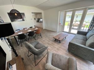 a living room with a couch and a table at europark chalet exclusif 6 in Otterlo