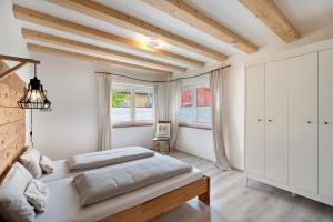 a bedroom with white walls and a bed and windows at Ferienhaus Schwarzwaldheimat in Bühl