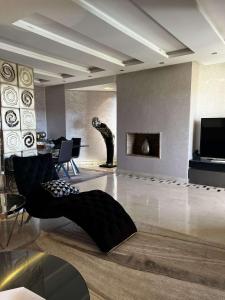 a living room with a black chair and a television at Appartement golf prestigia in Marrakesh