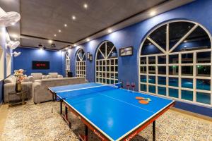 a ping pong table in a room with blue walls at Elivaas Enchantia Luxury 6BHK Villa with Pvt Pool in Gurgaon in Bhundsi
