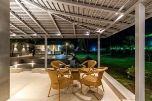 a patio with a table and chairs under a pergola at Elivaas Enchantia Luxury 6BHK Villa with Pvt Pool in Gurgaon in Bhundsi
