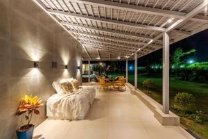 a covered porch with a bed and a table at Elivaas Enchantia Luxury 6BHK Villa with Pvt Pool in Gurgaon in Bhundsi