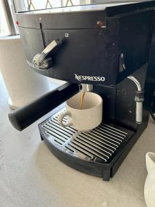 a espresso machine sitting on a counter with a cup at Modern, centrally located, beach view flat in Pevensey
