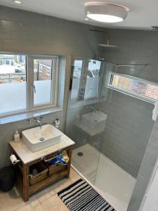 a bathroom with a sink and a shower at Modern, centrally located, beach view flat in Pevensey