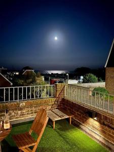 a wooden bench sitting on top of a balcony at Modern, centrally located, beach view flat in Pevensey