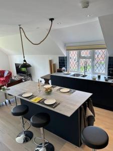 a kitchen with a large island with stools at Modern, centrally located, beach view flat in Pevensey