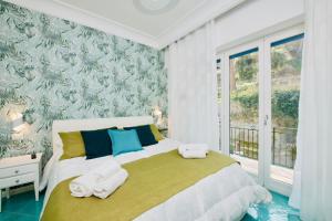 1 dormitorio con 1 cama grande y toallas. en Amalfia Apartments, en Amalfi