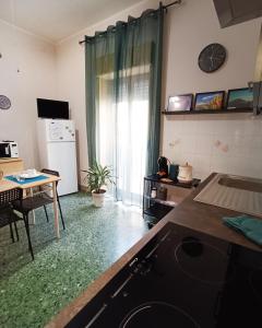 um quarto com uma cozinha com um frigorífico e uma mesa em Mylina apartment Milazzo em Milazzo