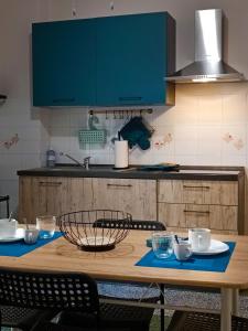 uma cozinha com uma mesa de madeira com pratos e chávenas em Mylina apartment Milazzo em Milazzo