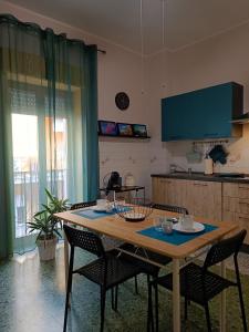 uma cozinha com uma mesa de madeira com cadeiras e uma mesa; em Mylina apartment Milazzo em Milazzo