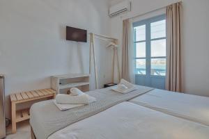a bedroom with a large bed and a window at Hotel Mantalena in Antiparos