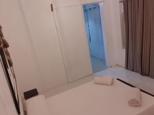 a white bathroom with a towel on the floor at L2B - São Vicente in Mindelo