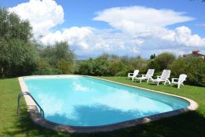 una piscina con 2 sillas de césped en Villa Olivo, en Lastra a Signa