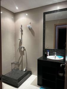 a bathroom with a sink and a shower with a mirror at Appartement golf prestigia in Marrakesh