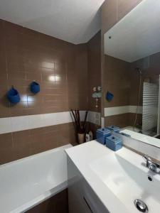 ein Badezimmer mit einem weißen Waschbecken und einem Spiegel in der Unterkunft Hortensias de jardín in O Grove