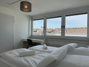 twee bedden in een kamer met twee ramen bij Penthouse in zentraler Lage in Pforzheim
