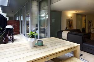a living room with a wooden table and a couch at Urban Sea Drift in Melbourne +12 photos