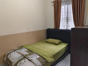 a small bed in a room with a window at Bajorah Villa in Lembang