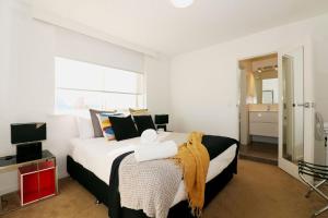1 dormitorio con 1 cama grande y TV en The Ivy on Munro en Melbourne
