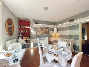a dining room with white tables and white chairs at Hotel Casa Arizzoli in Cannobio