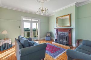 a living room with two couches and a fireplace at Hopkins River Homestead in Allansford