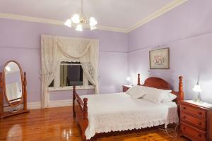 1 dormitorio con cama, espejo y tocador en Hopkins River Homestead en Allansford