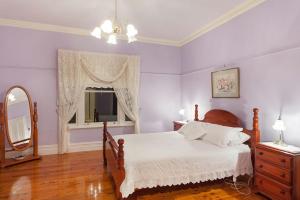a bedroom with a bed and a mirror and a dresser at Hopkins River Homestead in Allansford
