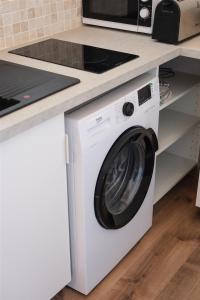 een witte wasmachine onder een aanrecht in een keuken bij Studio 2 personnes - Marseille in Marseille