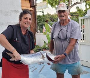Un uomo e una donna che tengono un pesce di La Nassa a San Domino