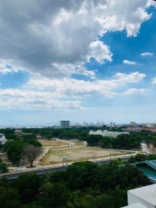 uma vista para um parque numa cidade sob um céu nublado em Hello condo em Manilla
