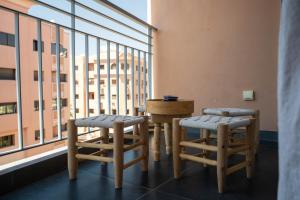 um quarto com duas cadeiras, uma mesa e uma janela em L'appart by Louhou Collection em Marraquexe
