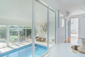een huis met een zwembad met glazen wanden bij Currawong Close Pool Pool Table Alfresco Featured in Cowes