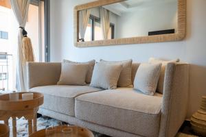 uma sala de estar com um sofá e um espelho em L'appart by Louhou Collection em Marrakech