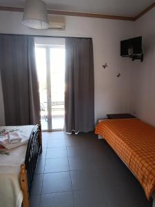a bedroom with two beds and a sliding glass door at GOLDEN BEACH in Souvala