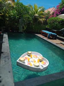 a tray of food in the water in a swimming pool at Mandox Villa Bali in Ungasan