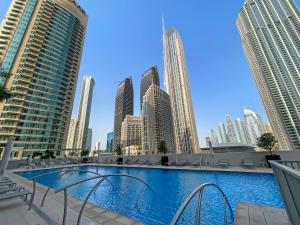 a large swimming pool in a city with tall buildings at Silkhaus Chic 1 BDR In a New Tower In Downtown in Dubai