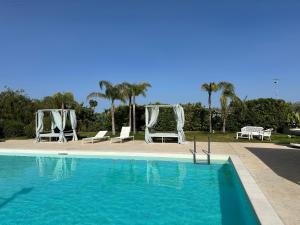 a swimming pool with two chairs and a couple ofitures at casa croma in Siracusa