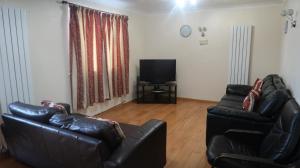 a living room with two leather couches and a television at Spacious 4 bed Farnborough AirShow in Blackwater