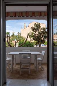 a table and chairs in a room with a window at Lido Holiday Home in Alghero