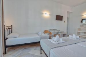 a room with two beds and a table with towels at Hotel Mantalena in Antiparos Town