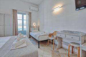 a bedroom with a bed and a desk and a bed at Hotel Mantalena in Antiparos Town