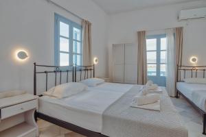 a bedroom with two beds with white towels on them at Hotel Mantalena in Antiparos Town