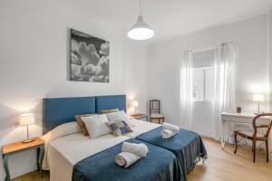 Un dormitorio con una cama azul con toallas. en Santa Cruz Art Home, en Santa Cruz de Tenerife